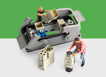 Bild ein Han domino Modulgehäuse, das durch 2 Miniaturfiguren von Mitarbeitern bestückt wird